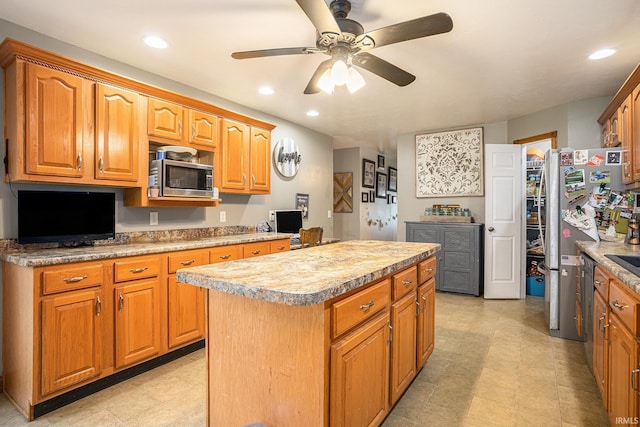 58380 Ash Rd, Osceola, IN 46561 - kitchen with stainless steel appliances, a center island, ceiling fan, light countertops, and light floors