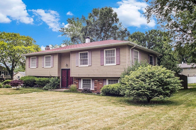 1356 Hampshire Dr, South Bend, IN 46614 - raised ranch featuring a chimney, a front lawn, and a metal roof