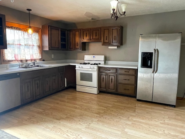 1710 N Webster St, Kokomo, IN 46901 - kitchen with stainless steel appliances, light countertops, light wood-style flooring, hanging light fixtures, and a chandelier