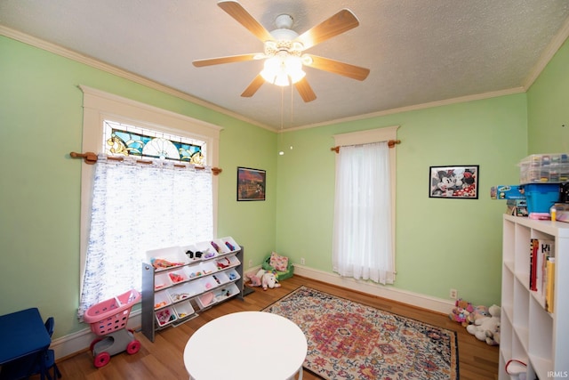 403 E Columbia St, Flora, IN 46929 - playroom featuring wood finished floors, a ceiling fan, and ornamental molding