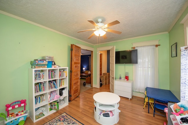 403 E Columbia St, Flora, IN 46929 - playroom featuring wood finished floors, a ceiling fan, ornamental molding, and a textured ceiling