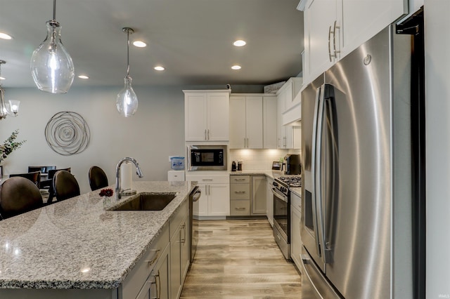 5573 Camden Dr, Newburgh, IN 47630 - kitchen featuring stainless steel appliances, light wood-style flooring, an island with sink, recessed lighting, and tasteful backsplash