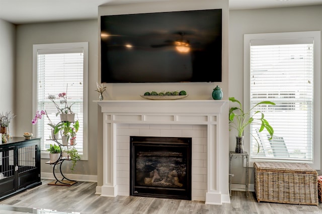 5573 Camden Dr, Newburgh, IN 47630 - living area featuring wood finished floors, a tiled fireplace, and healthy amount of natural light