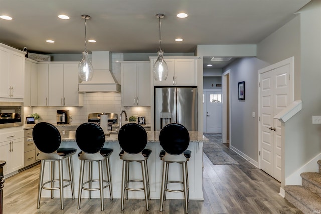 5573 Camden Dr, Newburgh, IN 47630 - kitchen featuring stainless steel fridge with ice dispenser, custom exhaust hood, built in microwave, backsplash, and light wood-style floors