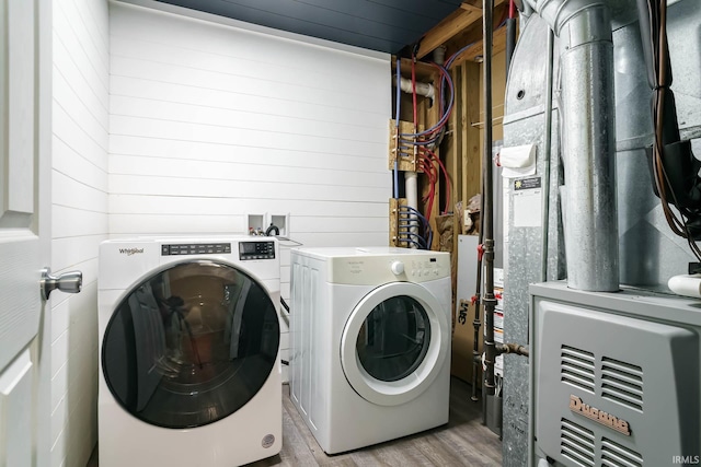 5209 Jenny Ln, Mishawaka, IN 46545 - washroom featuring washing machine and clothes dryer, light wood-style flooring, wooden walls, and heating unit