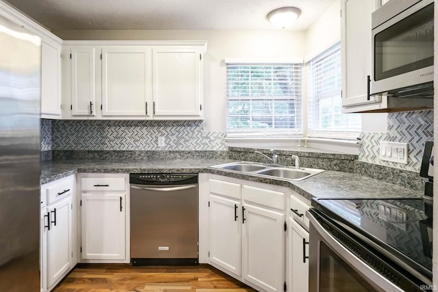5209 Jenny Ln, Mishawaka, IN 46545 - kitchen with appliances with stainless steel finishes, white cabinetry, wood finished floors, and decorative backsplash
