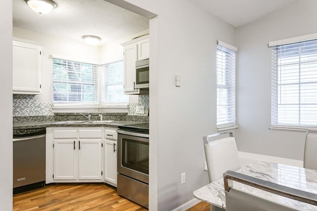 5209 Jenny Ln, Mishawaka, IN 46545 - kitchen with stainless steel appliances, backsplash, dark countertops, and white cabinets