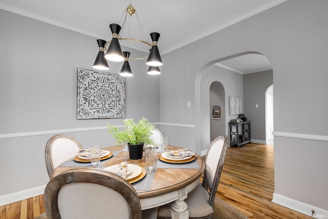 415 Wakewa Ave, South Bend, IN 46617 - dining area featuring arched walkways, wood finished floors, crown molding, and a chandelier