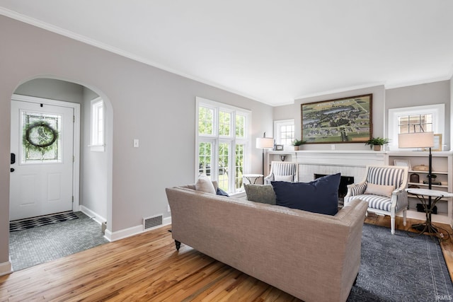 415 Wakewa Ave, South Bend, IN 46617 - living area featuring wood finished floors, crown molding, arched walkways, and a brick fireplace