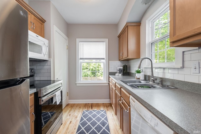 415 Wakewa Ave, South Bend, IN 46617 - kitchen with stainless steel appliances, healthy amount of natural light, light wood finished floors, and decorative backsplash