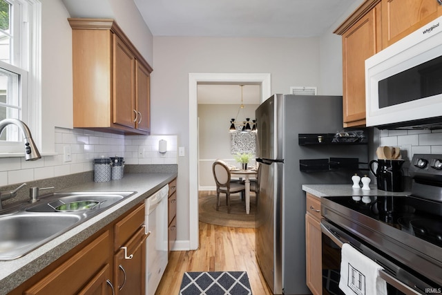 415 Wakewa Ave, South Bend, IN 46617 - kitchen featuring white appliances, light wood-style floors, tasteful backsplash, brown cabinetry, and dark countertops