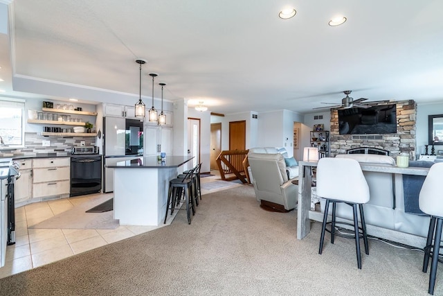 280 Ln 230 Jimmerson Lk, Angola, IN 46703 - kitchen featuring freestanding refrigerator, dark countertops, a breakfast bar area, a ceiling fan, and a fireplace