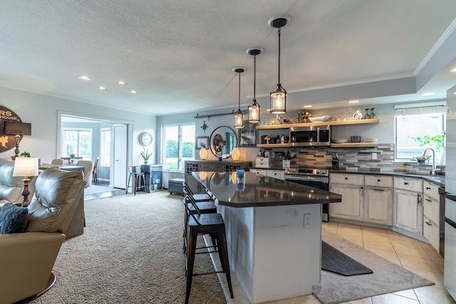 280 Ln 230 Jimmerson Lk, Angola, IN 46703 - kitchen featuring appliances with stainless steel finishes, dark countertops, tasteful backsplash, ornamental molding, and open floor plan