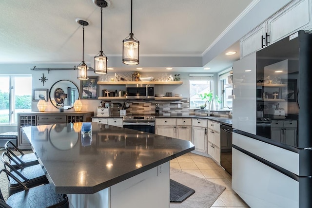 280 Ln 230 Jimmerson Lk, Angola, IN 46703 - kitchen with stainless steel appliances, dark countertops, ornamental molding, plenty of natural light, and tasteful backsplash
