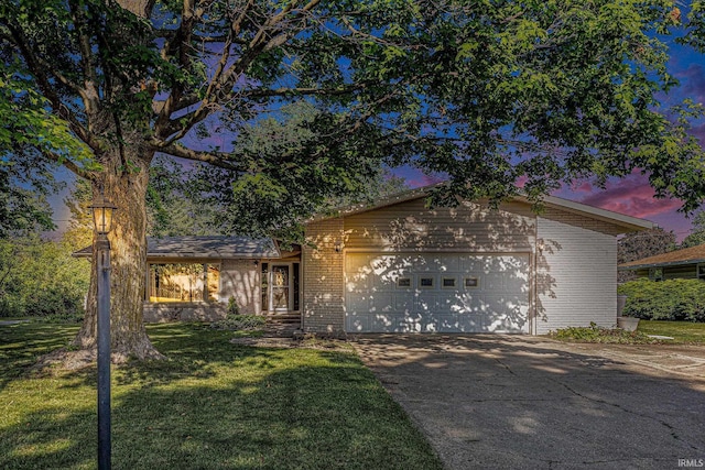 60220 Robin Hood Ln, Elkhart, IN 46517 - view of front of house with brick siding, driveway, a garage, and a front yard