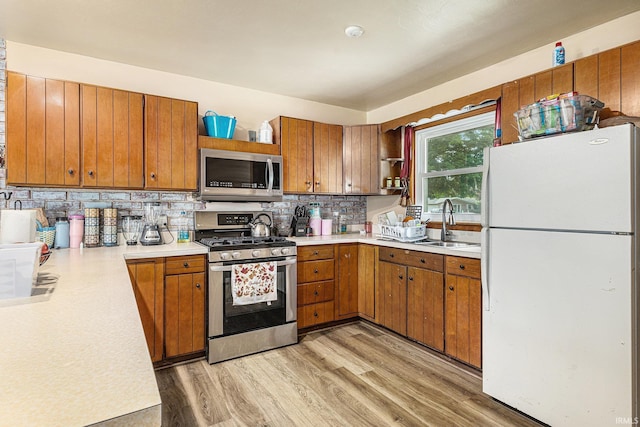 60220 Robin Hood Ln, Elkhart, IN 46517 - kitchen featuring appliances with stainless steel finishes, open shelves, light wood-style flooring, brown cabinets, and light countertops