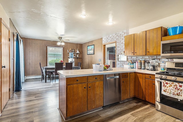 60220 Robin Hood Ln, Elkhart, IN 46517 - kitchen with appliances with stainless steel finishes, a peninsula, light countertops, and wood finished floors