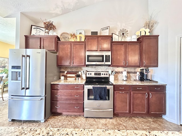 3607 Regatta Dr, Lafayette, IN 47909 - kitchen with stainless steel appliances, tasteful backsplash, a textured ceiling, light stone countertops, and vaulted ceiling