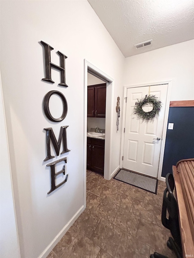 3607 Regatta Dr, Lafayette, IN 47909 - entryway featuring a textured ceiling and dark stone finish flooring