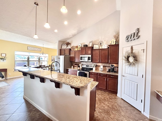 3607 Regatta Dr, Lafayette, IN 47909 - kitchen featuring stainless steel appliances, a breakfast bar, tasteful backsplash, tile patterned floors, and hanging light fixtures