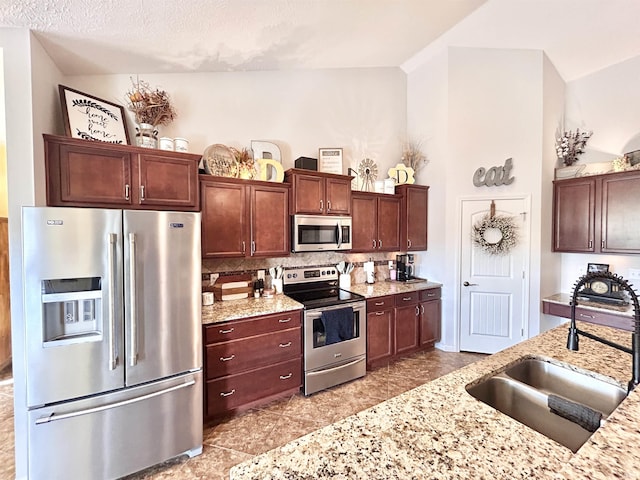3607 Regatta Dr, Lafayette, IN 47909 - kitchen with stainless steel appliances, decorative backsplash, lofted ceiling, and light stone counters