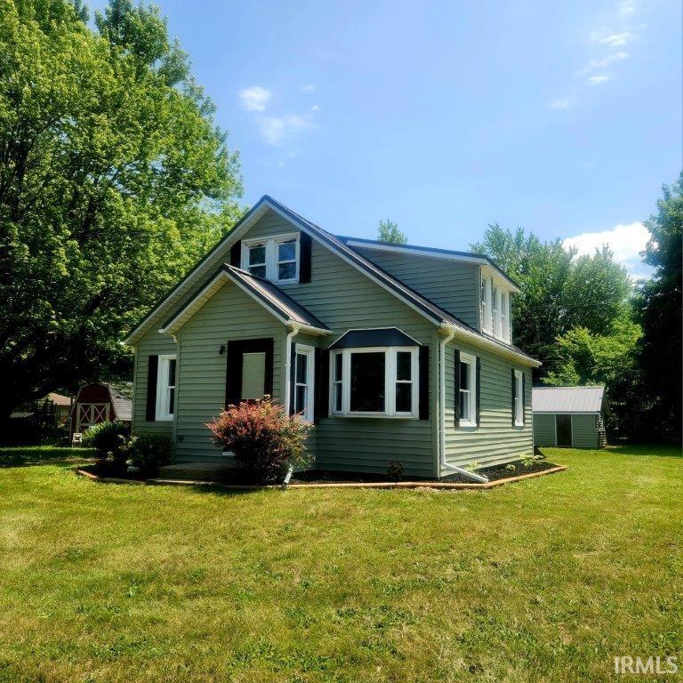 422 N Main St, Millersburg, IN 46543 - view of front of house with a front yard and an outbuilding