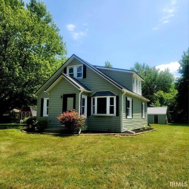 422 N Main St, Millersburg, IN 46543 - view of front of house with a front yard and an outbuilding