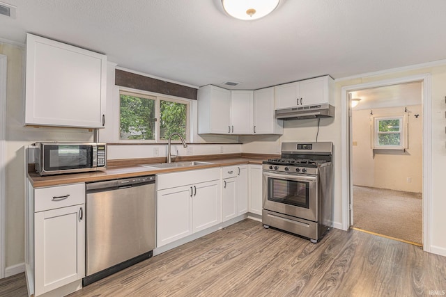 30161 Wolf Ave, Elkhart, IN 46516 - kitchen featuring appliances with stainless steel finishes, under cabinet range hood, light wood-style flooring, white cabinets, and wooden counters