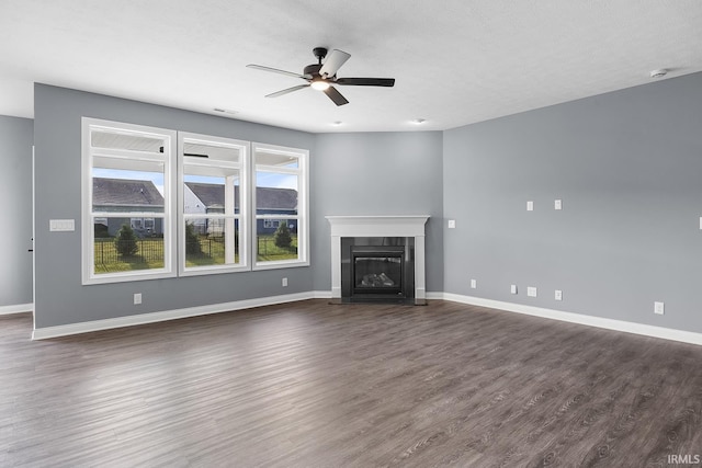 323 Haddington Ln, Lafayette, IN 47905 - unfurnished living room featuring ceiling fan, dark wood-type flooring, and a glass covered fireplace