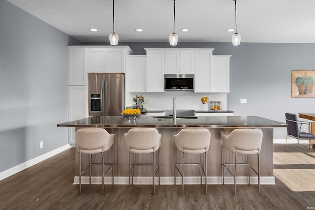 323 Haddington Ln, Lafayette, IN 47905 - kitchen with stainless steel appliances, dark countertops, an island with sink, dark wood-style flooring, and recessed lighting