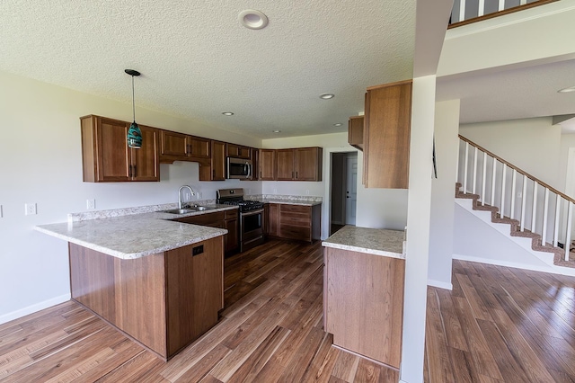 5205 Pigeon Creek Ct, Fort Wayne, IN 46825 - kitchen featuring stainless steel appliances, dark wood-style floors, a textured ceiling, a peninsula, and light countertops