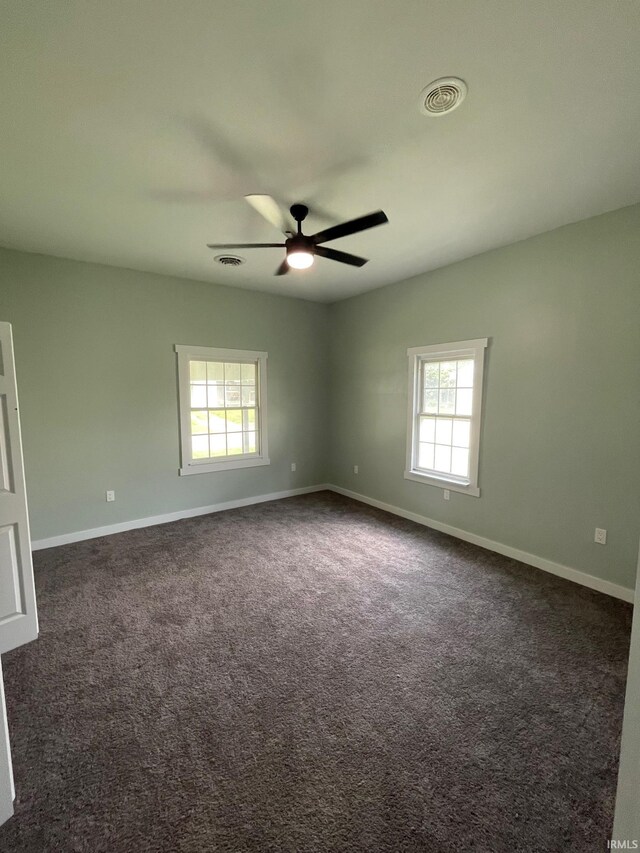 312 E 2nd St, Bicknell, IN 47512 - empty room featuring plenty of natural light, a ceiling fan, and dark colored carpet