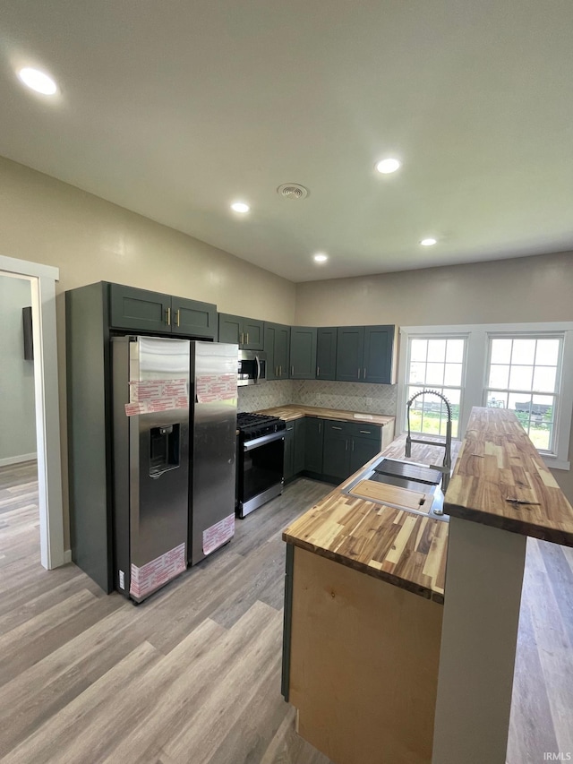 312 E 2nd St, Bicknell, IN 47512 - kitchen with appliances with stainless steel finishes, butcher block countertops, light wood finished floors, tasteful backsplash, and recessed lighting
