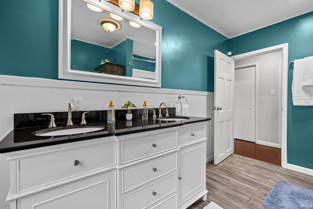 51881 Currant Rd, Granger, IN 46530 - bathroom with double vanity, a wainscoted wall, and wood finished floors