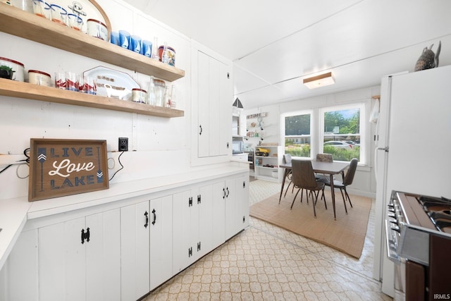 387 Ems T26 Ln, Leesburg, IN 46538 - kitchen with high end stainless steel range, open shelves, light countertops, and white cabinetry