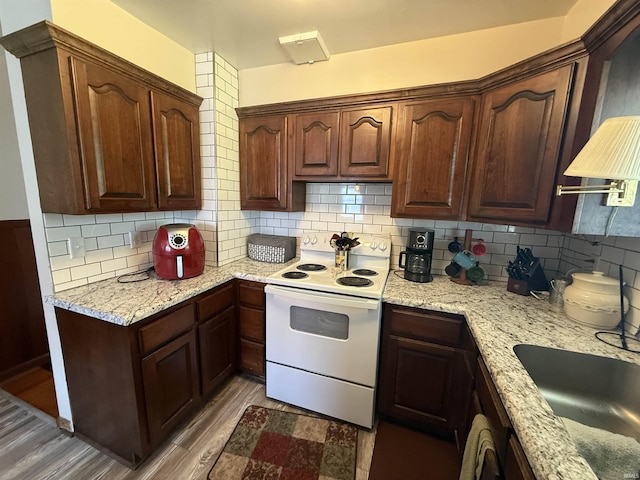 305 S Grove St, Odon, IN 47562 - kitchen with electric range, tasteful backsplash, wood finished floors, and light stone countertops