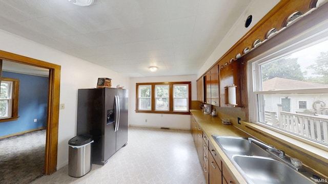 1219 Oakland St, Fort Wayne, IN 46808 - kitchen with stainless steel fridge with ice dispenser, brown cabinets, and light countertops