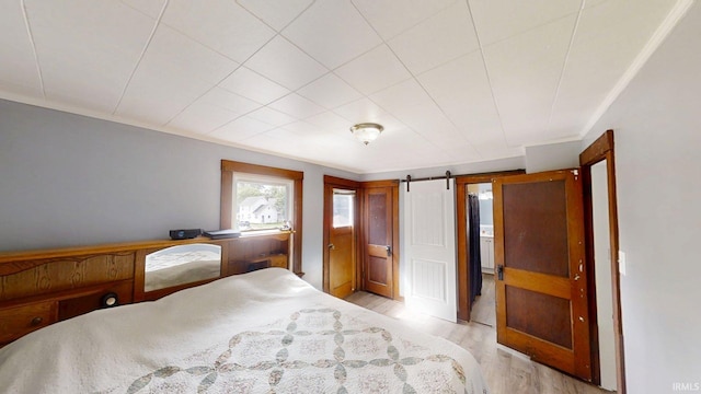 1219 Oakland St, Fort Wayne, IN 46808 - bedroom with light wood-style floors and a barn door