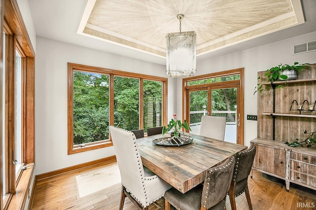 55623 Little Creek Ln, Middlebury, IN 46540 - dining area featuring a raised ceiling, hardwood / wood-style floors, a chandelier, and crown molding