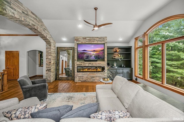 55623 Little Creek Ln, Middlebury, IN 46540 - living room featuring wood finished floors, arched walkways, a fireplace, a ceiling fan, and lofted ceiling