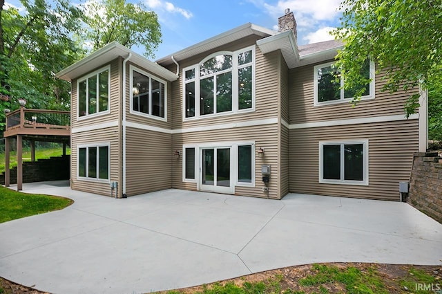 55623 Little Creek Ln, Middlebury, IN 46540 - back of house featuring a chimney, a wooden deck, and a patio