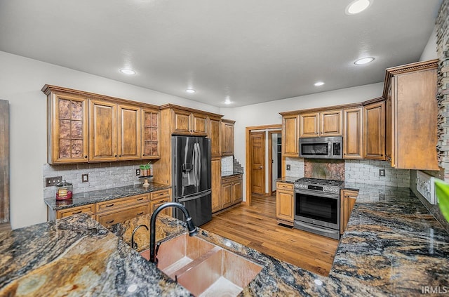 55623 Little Creek Ln, Middlebury, IN 46540 - kitchen featuring stainless steel appliances, brown cabinetry, recessed lighting, backsplash, and light wood finished floors