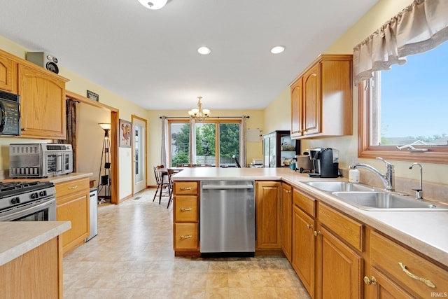 1108 Willen Ln, Fort Wayne, IN 46818 - kitchen with stainless steel appliances, a peninsula, a chandelier, light countertops, and recessed lighting
