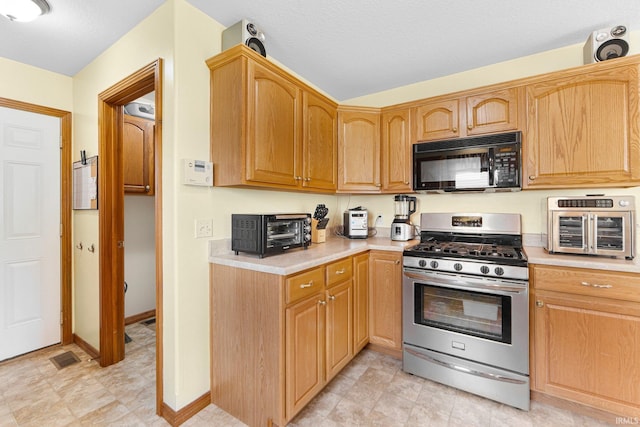 1108 Willen Ln, Fort Wayne, IN 46818 - kitchen featuring gas range, black microwave, and light countertops