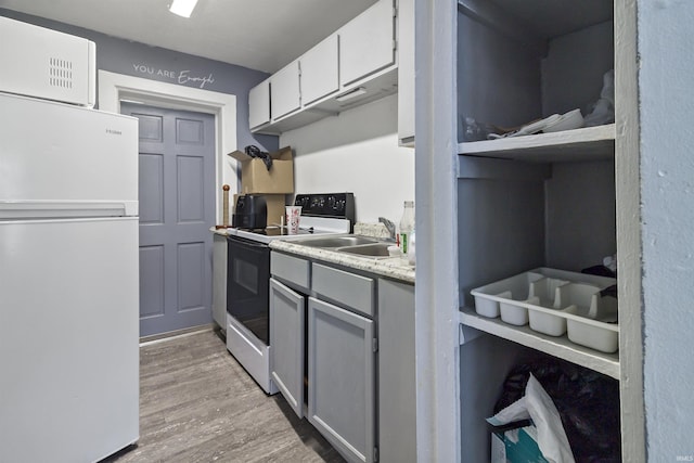 225 N E St, Marion, IN 46952 - kitchen with freestanding refrigerator, range with electric cooktop, light wood-style flooring, light countertops, and gray cabinets