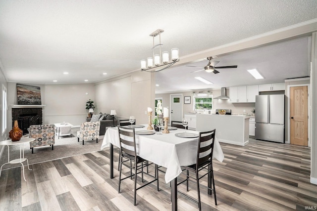 17725 Douglas Rd, South Bend, IN 46635 - dining room with wood finished floors, ceiling fan, recessed lighting, crown molding, and a fireplace with raised hearth
