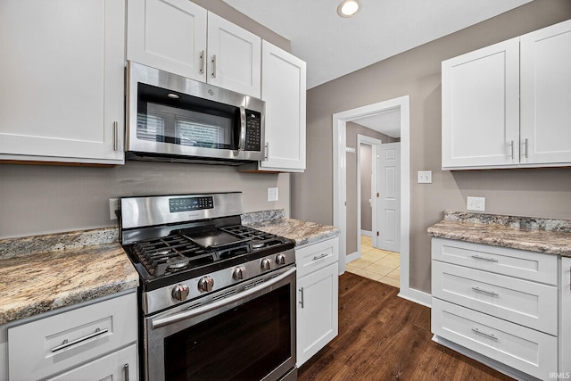 119 Towle Ave, Mishawaka, IN 46544 - kitchen featuring appliances with stainless steel finishes, white cabinets, dark wood-style flooring, light stone countertops, and recessed lighting