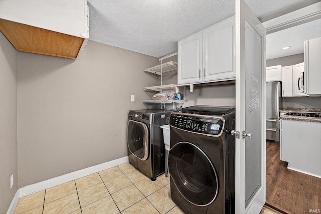 119 Towle Ave, Mishawaka, IN 46544 - washroom featuring cabinet space, independent washer and dryer, light tile patterned floors, and a textured ceiling