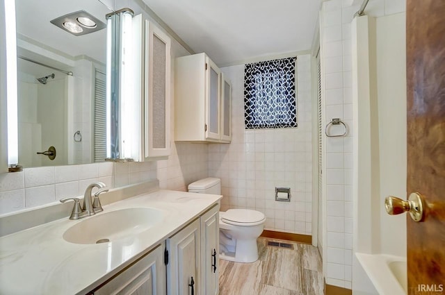 1049 Chapman Lake Dr, Warsaw, IN 46582 - bathroom with tile walls, vanity, and washtub / shower combination