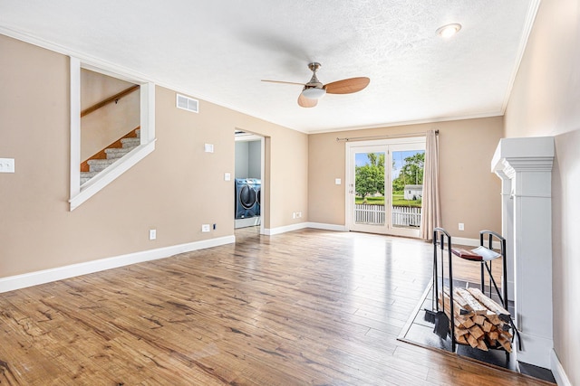 51268 Channel Ct, Elkhart, IN 46514 - unfurnished living room featuring washer and dryer, a ceiling fan, wood finished floors, ornamental molding, and stairs